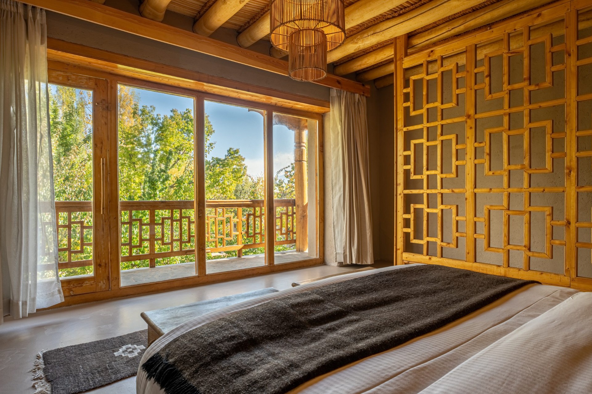 Dolkhar bedroom with wooden lattice screens and mountain views