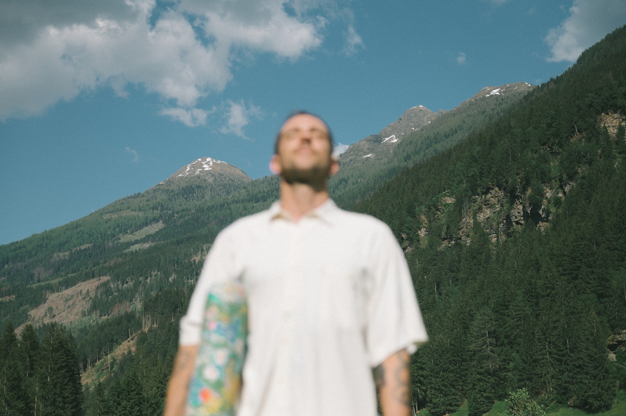 A figure standing before alpine mountains
