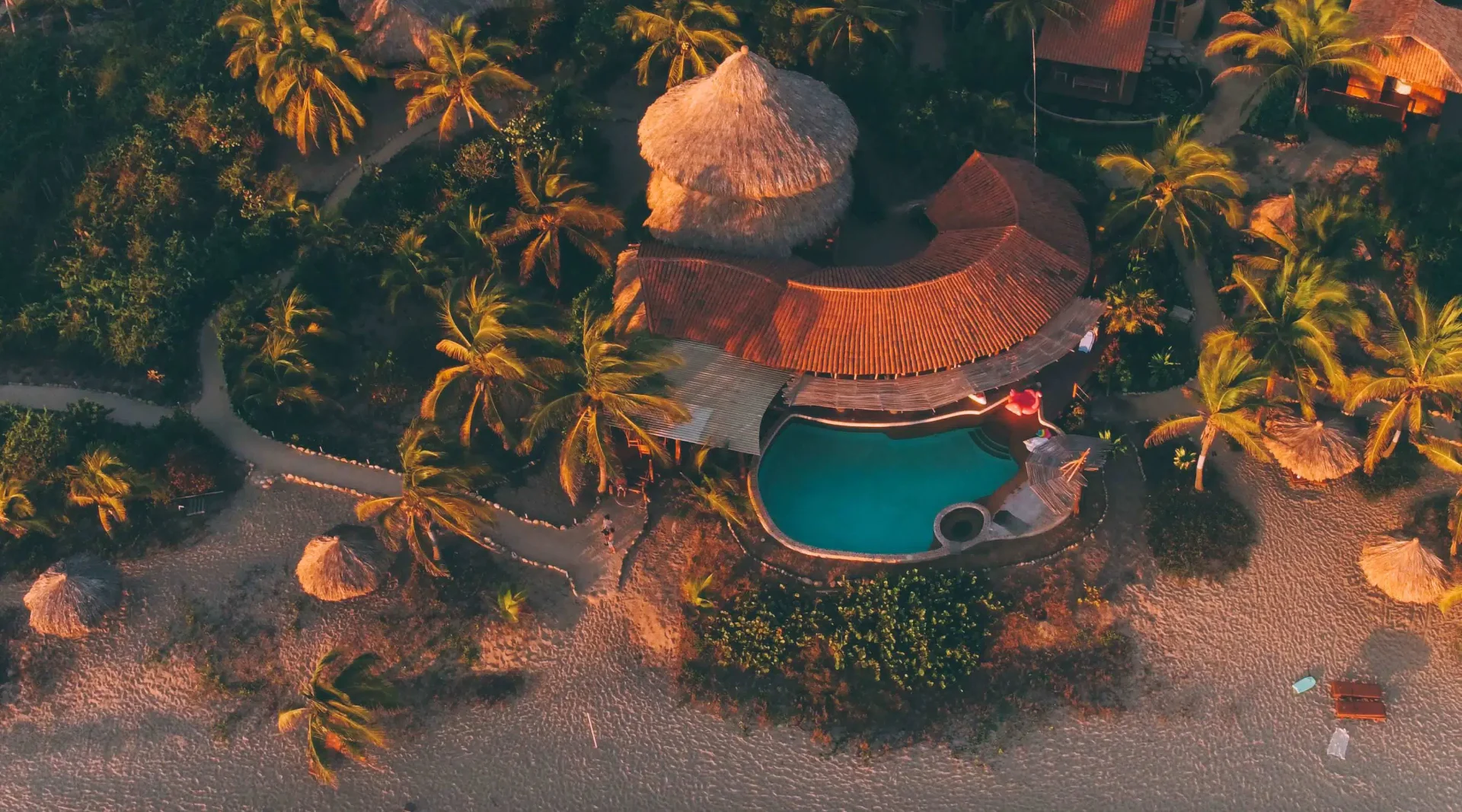 Aerial view of Playa Viva's thatched main palapa and pool beside the Pacific Ocean