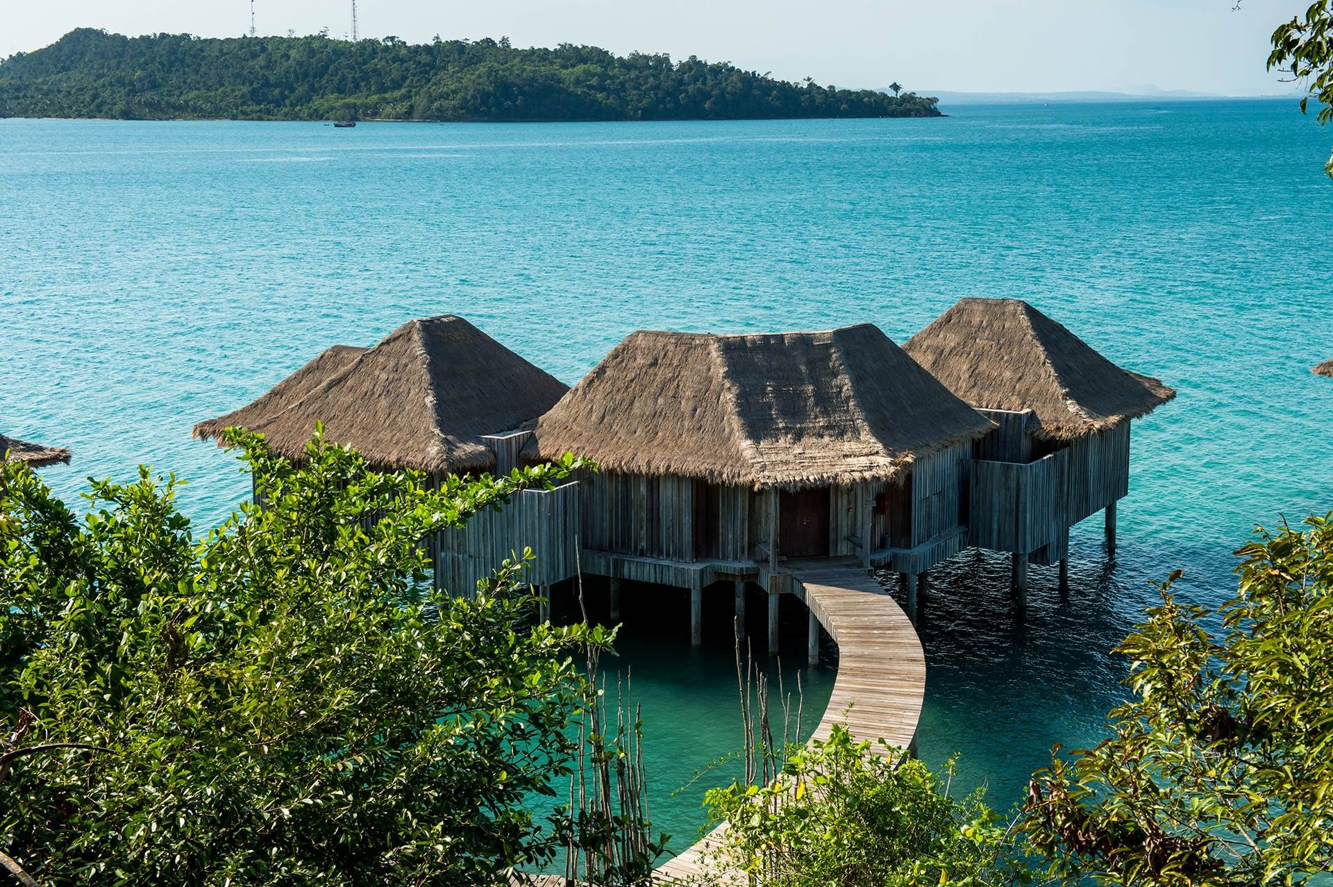 Thatched overwater villas connected by wooden walkway