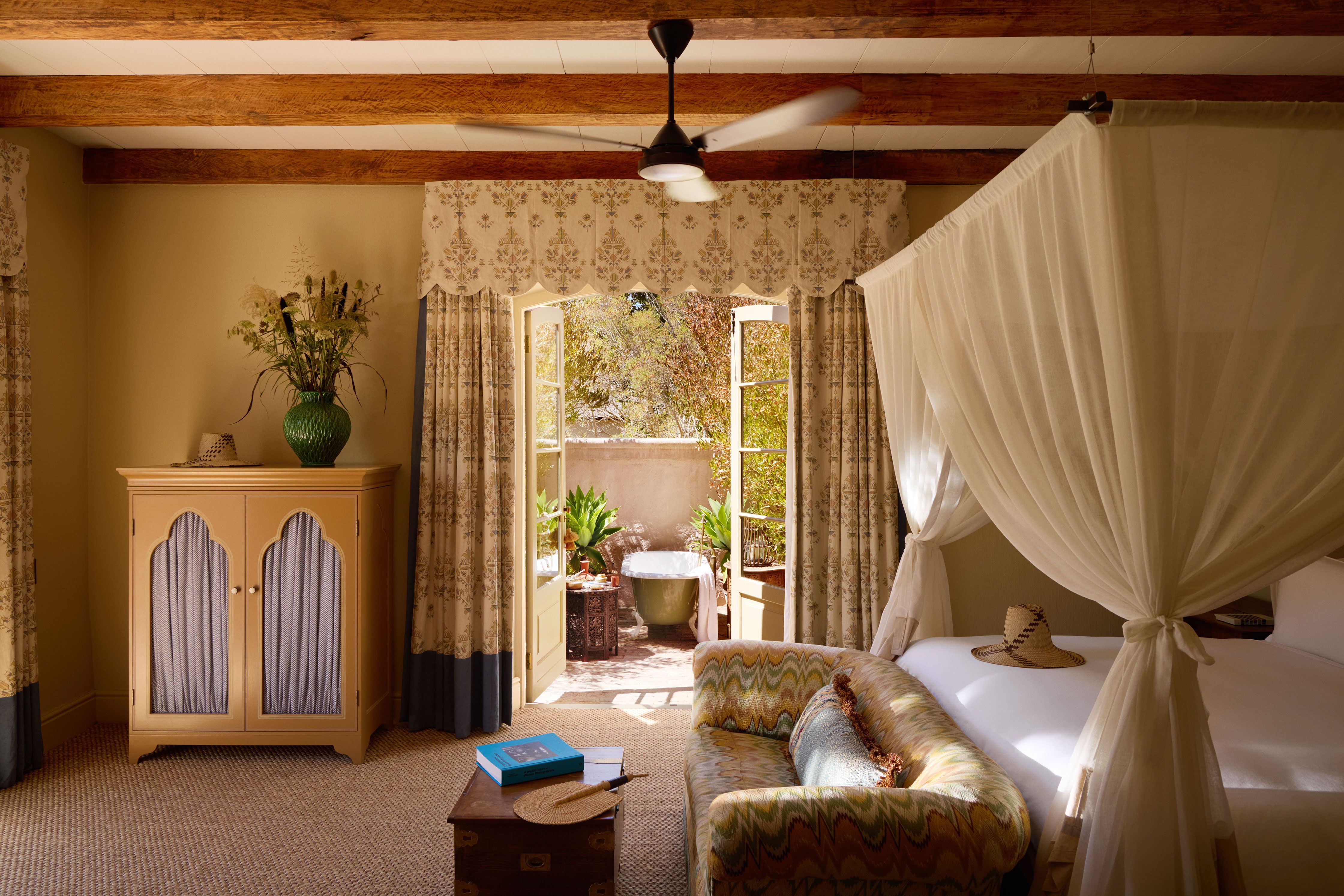 Sunlit bedroom opening onto private courtyard bath