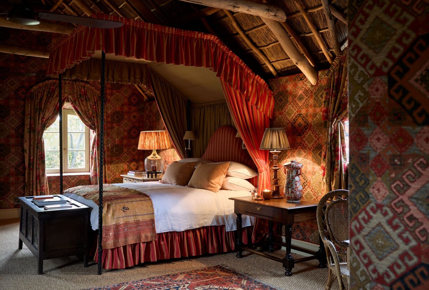 Heritage bedroom with rich textiles and thatched ceiling