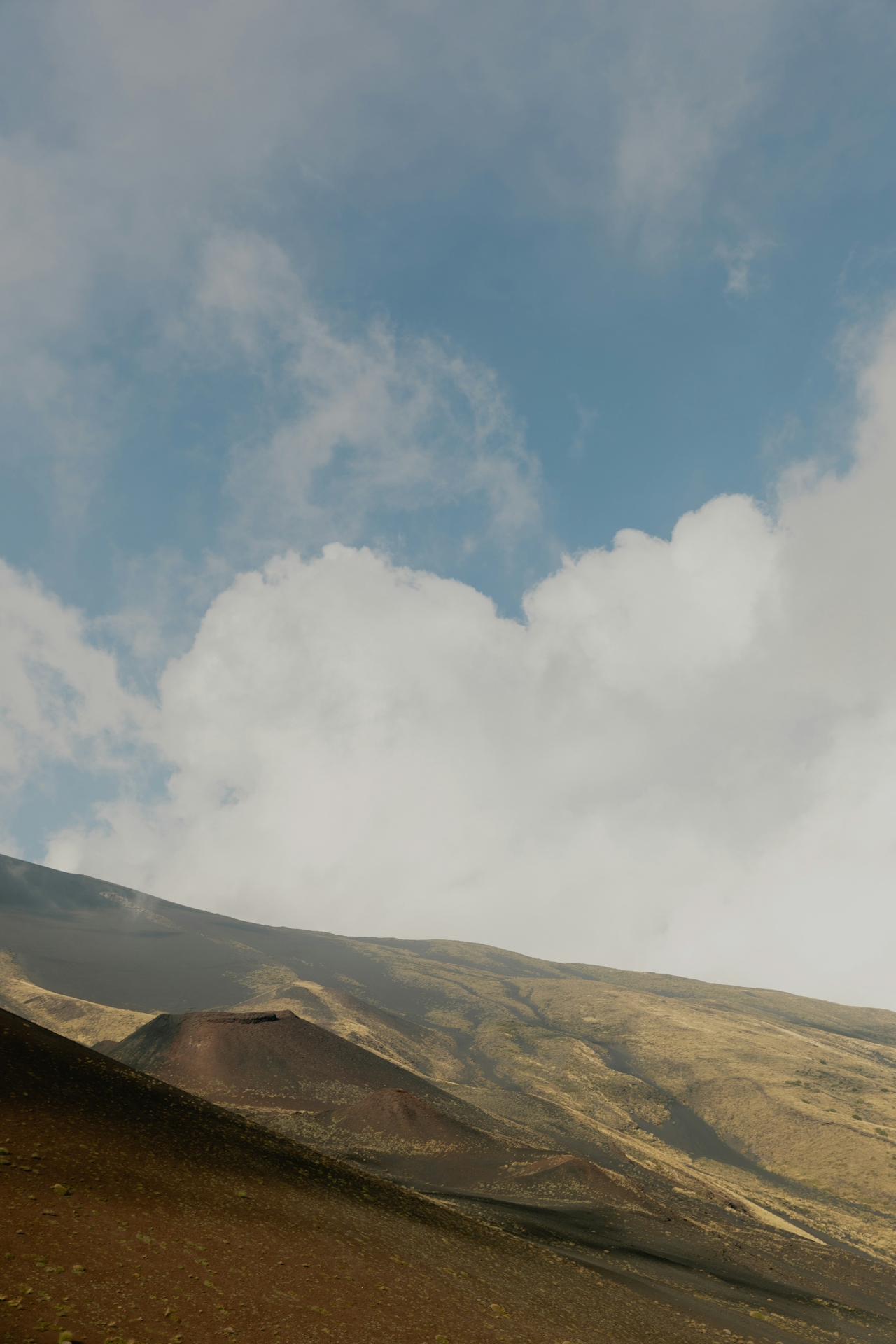 Volcanic slope under shifting clouds — the long memory of the land